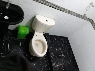 a bathroom with a white toilet and a sink at La Esquina de Doña Julia in Lima