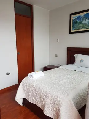 a bedroom with a bed and a wooden door at Hotel Luz de Luna in Atico