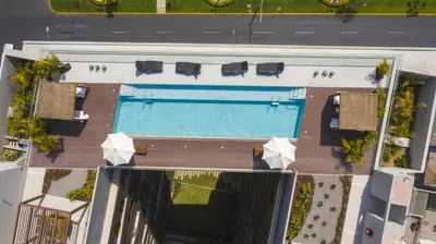 an overhead view of a pool with chairs and umbrellas at ✶ Pisac Penthouse ✶ 3-stories LUXURY Rooftop Pool in Lima