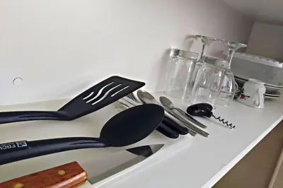 a kitchen counter with utensils on a counter top at Residencial Suiza in Lima