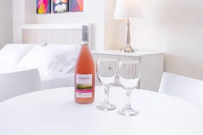 a bottle of wine and two wine glasses on a table at Residencial Suiza in Lima