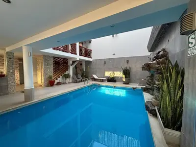 an indoor swimming pool with blue water in a house at El Gamonal - Paracas in Paracas