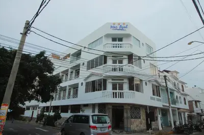 a white building with a car parked in front of it at Mar Azul in Paracas