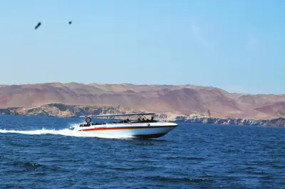 a boat in the middle of a body of water at Mar Azul in Paracas