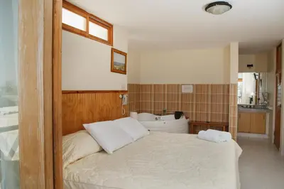 a bedroom with a bed and a tub and a sink at Hotel Emancipador in Paracas