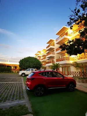 a red car parked in front of a building at Hotel Emancipador in Paracas