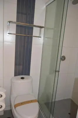 a bathroom with a toilet and a glass shower at Hotel Los Flamencos in Paracas