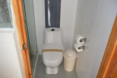 a small bathroom with a toilet and a trash can at Hotel Los Flamencos in Paracas