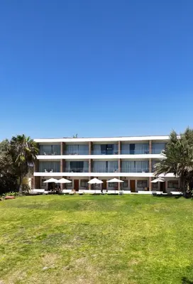 a large building with umbrellas in front of it at Hotel El Condor in Paracas