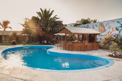 a swimming pool in front of a building at Hotel El Condor in Paracas