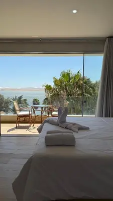 a bedroom with a bed with a view of the ocean at Hotel El Condor in Paracas