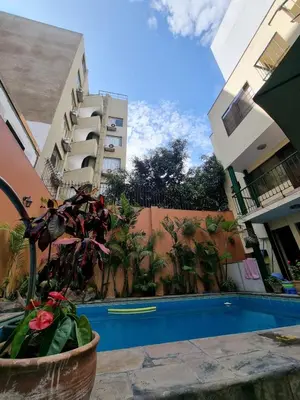 a swimming pool in the middle of two buildings at Llaqta Wasi in Lima