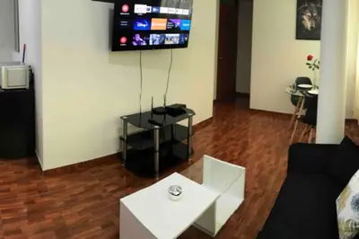 a living room with a couch and a table and a tv at 200. Hermoso Departamento con Servicios Incluidos en Chorrillos in Lima