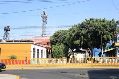a yellow fence on the side of a city street at Qurpawasi in Lima