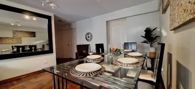 a dining room with a glass table with plates on it at Habitación Privada en departamento Compartido in Lima