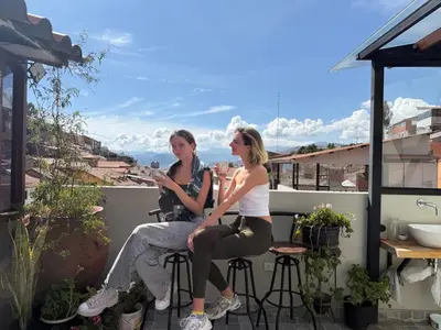 two women sitting on top of a balcony at Casa Agustina in Cusco