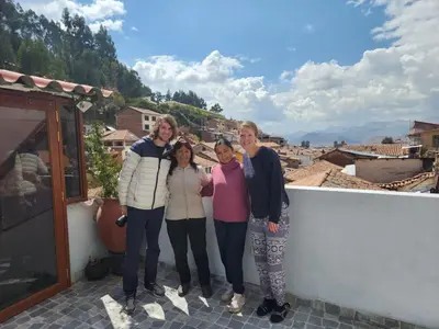 a group of people posing for a picture on a wall at Casa Agustina in Cusco