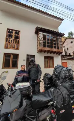 two men standing in front of a house with motorcycles at Casa Agustina in Cusco