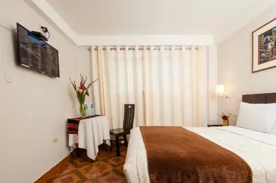 a hotel room with a bed and a table at KASAS DEL INKA MACHUPICCHU in Machu Picchu