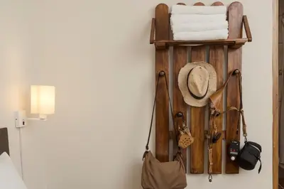 a wall with a shelf with a hat and towels at KASAS DEL INKA MACHUPICCHU in Machu Picchu