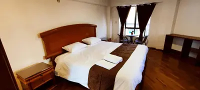 a bedroom with a large bed with two towels on it at Elsa Wasi Cusco in Cusco