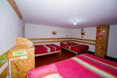 a bedroom with two beds in a room at Ukukus Hostel in Cusco