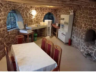 a kitchen with a table and a kitchen with a stone wall at Illa Wasi Sacred Valley in Urubamba
