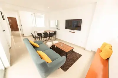 a living room with a blue couch and a table at Moderno Departamento en Barranca in Barranca