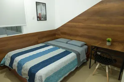 a small bedroom with a bed and a desk at Moderno Departamento en Barranca in Barranca