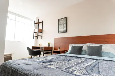 a bedroom with a large bed with a wooden headboard at Moderno Departamento en Barranca in Barranca