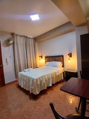 a hotel room with a bed and a table and a table sidx sidx at Hotel Residencial San Isidro in Hualmay