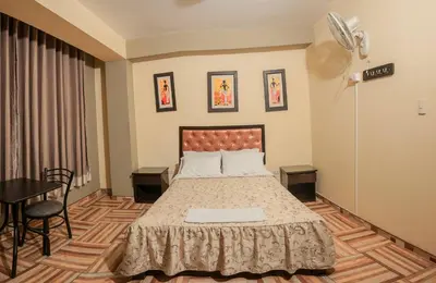 a bedroom with a bed and a table and chairs at Hotel Residencial San Isidro in Hualmay
