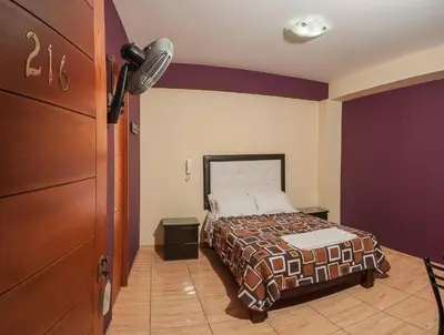a bedroom with a bed and a microphone in a room at Hotel Residencial San Isidro in Hualmay