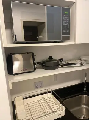 a kitchen with a microwave and a sink at Suite en San Isidro-Frente al Supermercado Vivanda in Lima