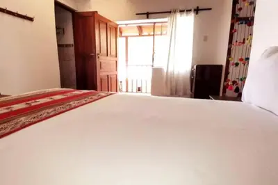 a large white bed in a room with a window at APARMENT SAMANA HOUSE OLLANTAYTAMBO in Ollantaytambo