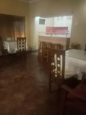 a living room with a table and chairs and a kitchen at Hospedaje Schell in Lima