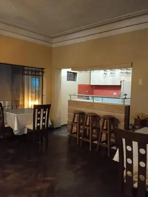 a kitchen with a table and some chairs and a counter at Hospedaje Schell in Lima