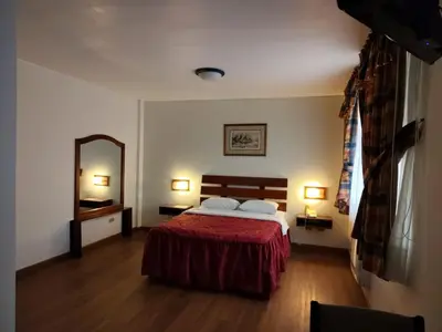 a bedroom with a bed and a large mirror at Los Mirtos suite & Hotel in Lima