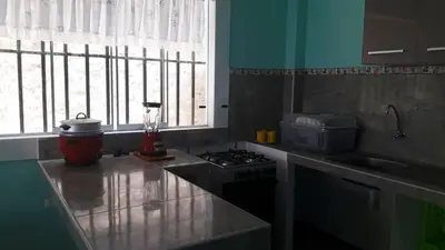 a kitchen with a stove and a sink and a window at IntiPunku in Cerro Azul