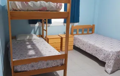 a small room with two bunk beds and a bed at IntiPunku in Cerro Azul