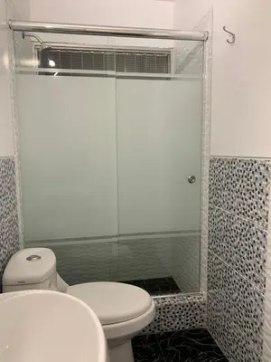 a bathroom with a toilet and a glass shower at Miraflores Center - Larcomar, Parque Kennedy, Malecón in Lima