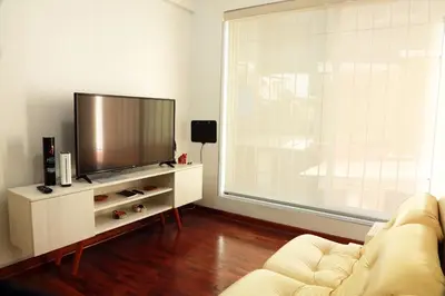 a living room with a couch and a flat screen tv at Miraflores Center - Larcomar, Parque Kennedy, Malecón in Lima