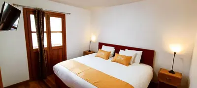 a bedroom with a large white bed with pillows at 7th Wonder Apart Hotel Cusco in Cusco