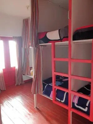 a room with two bunk beds with a red ladder at SK Hostal in Cusco