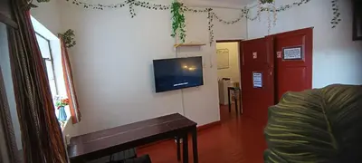 a living room with a flat screen tv on a wall at SK Hostal in Cusco