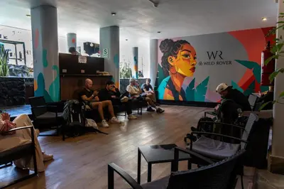 a group of people sitting in a room with a mural at Wild Rover Huacachina in Ica