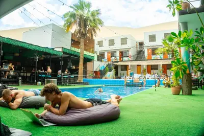 two young men laying on an inner tube in a pool at Wild Rover Huacachina in Ica