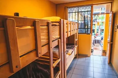 two bunk beds in a room with a window at Wild Rover Huacachina in Ica