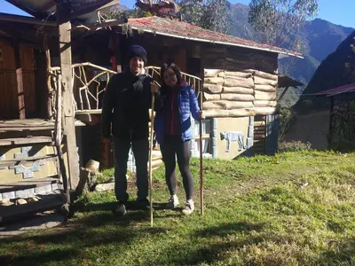 a man and a woman standing in front of a cabin at Salkantay Hostel Chaullay in Santa Teresa