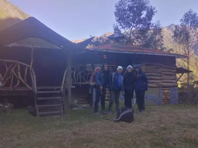 a group of people standing in front of a cabin at Salkantay Hostel Chaullay in Santa Teresa